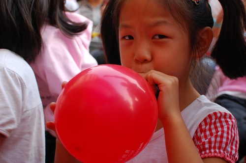 http://commons.wikimedia.org/wiki/File:Girl\_inflating\_a\_red\_balloon.jpg